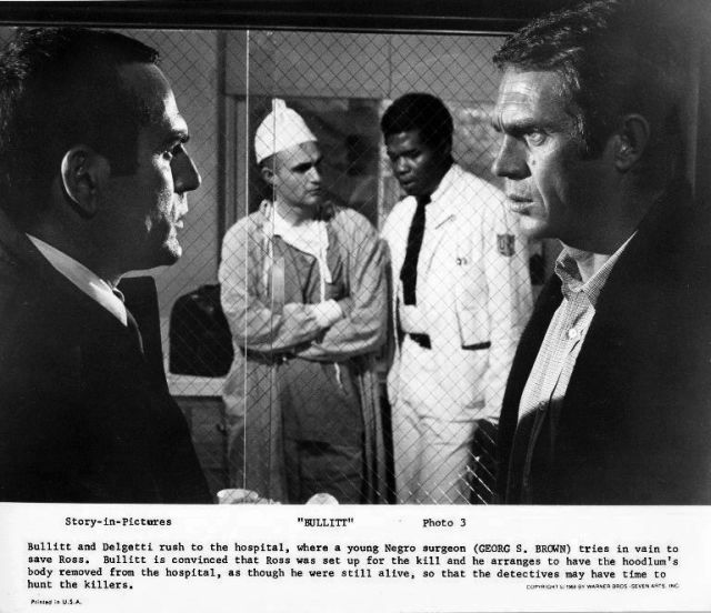 Detective Delgetti (Don Gordon) and 
Bullitt (Steve McQueen) discuss their case, 
as the doctor (Georg Stanford Brown) and 
nurse discuss the patient in the background.