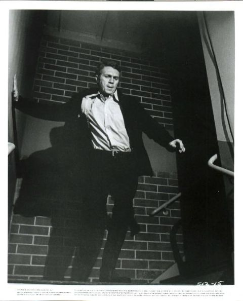 Frank Bullitt running down stairs in pursuit of assassin.
