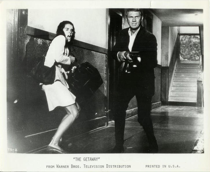Doc (McQueen) with Carol (Ali MacGraw) at his side, 
shoots his way out of a bad situation.