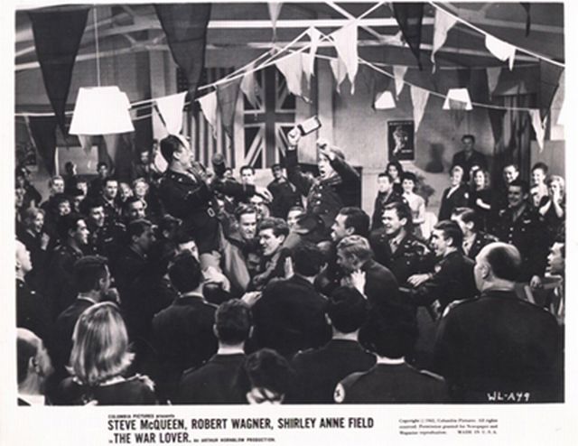 Steve McQueen (as Buzz Rickson) held on his men's shoulders, as they celebrate the success of a mission.